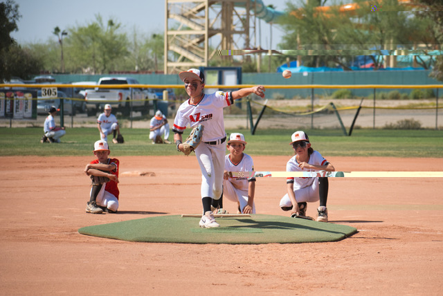 An AZ643 pitcher mid-delivery with infielders set behind the mound